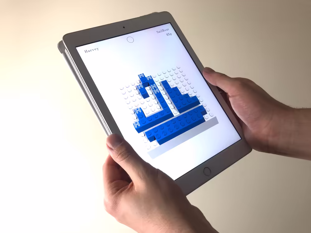 The app presents the virtual model on a rendered build plate of the same unit size as the build plate of the physical interface. The app presents additional information including the users name, the editing mode status (on or off), the current model name, and the estimated cost.