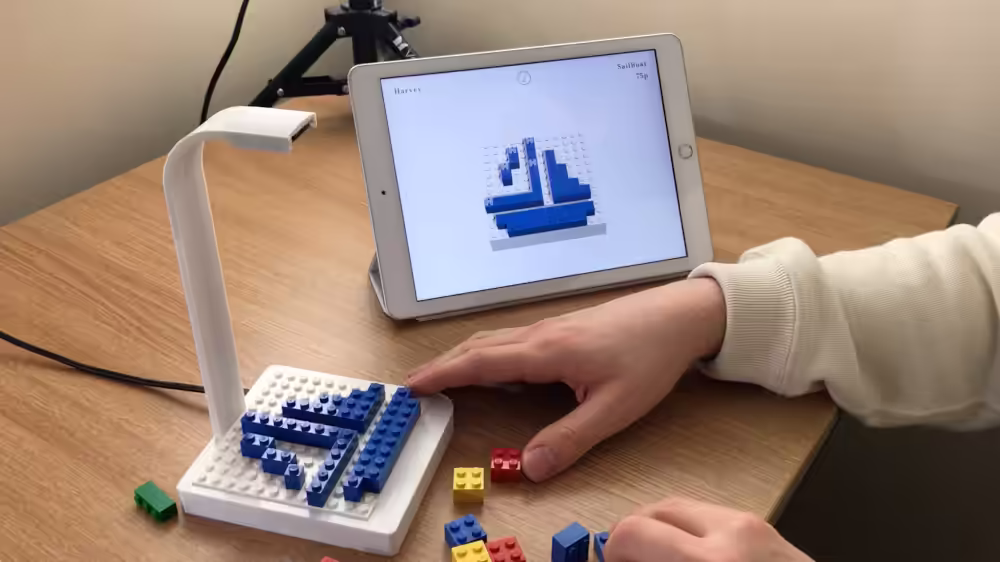 When collaborating on a design, each participant uses a build plate interface and mobile device running the application. The participant has a selection of toy construction bricks which can be placed on the build plate interface based upon their design suggestions or to match other collaborators' design suggestions.